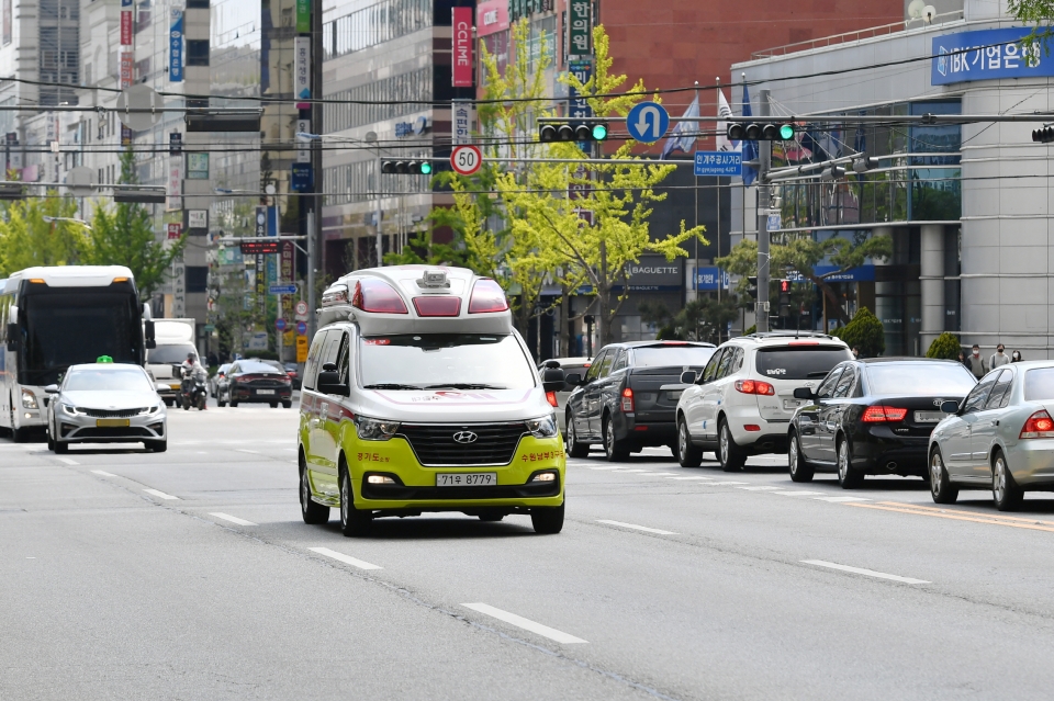 구급차량이 교차로에서 녹색신호를 받고 통과하는 모습.